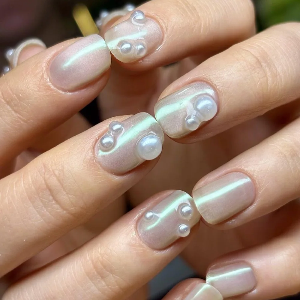Manicure hybrydowy nude z perłowymi 3D akcentami, wykonany w Norm